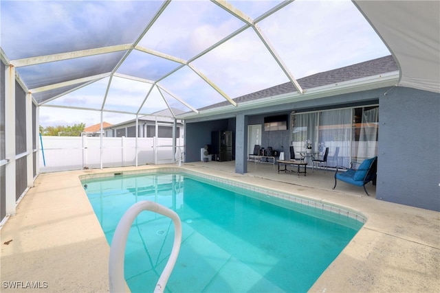 view of swimming pool featuring glass enclosure and a patio