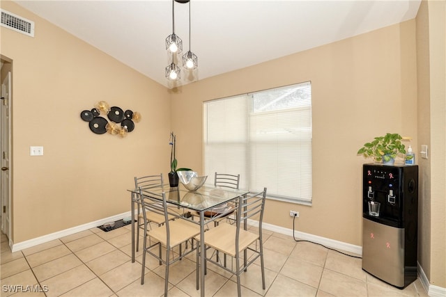 dining area with lofted ceiling and light tile patterned flooring