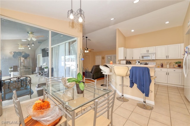 kitchen featuring decorative light fixtures, white appliances, light tile patterned flooring, lofted ceiling, and white cabinets