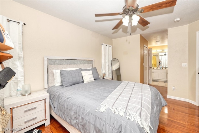 bedroom featuring ceiling fan, connected bathroom, and dark hardwood / wood-style floors