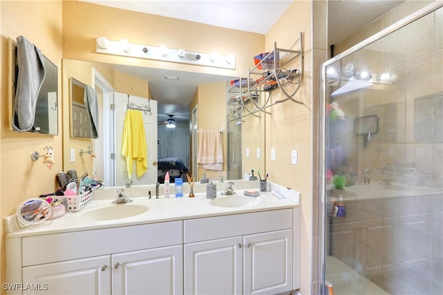 bathroom with ceiling fan, a shower with shower door, and vanity