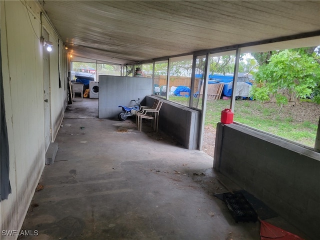 unfurnished sunroom featuring washer and dryer