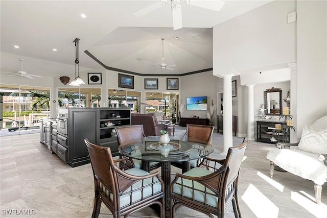 dining area with decorative columns, ceiling fan, and vaulted ceiling