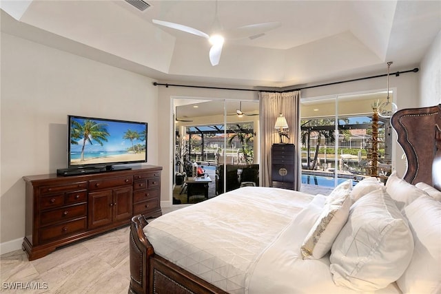 bedroom featuring ceiling fan, a raised ceiling, and access to outside