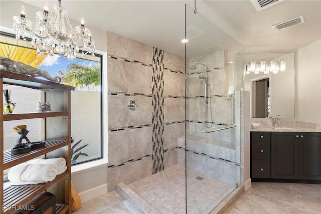 bathroom featuring tiled shower, vanity, a wealth of natural light, and a notable chandelier