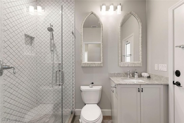 bathroom with vanity, toilet, and a shower with shower door