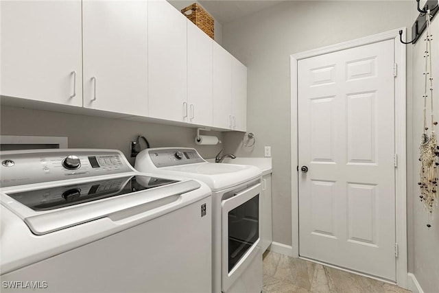 laundry area featuring cabinets, washing machine and dryer, and a barn door