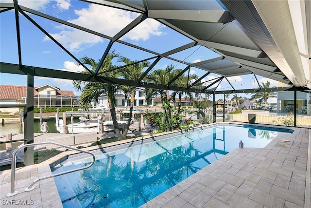 view of swimming pool with glass enclosure, a water view, a patio, and a dock