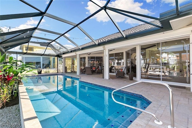 view of pool with ceiling fan, a patio area, and a lanai