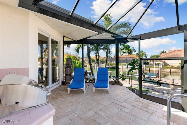 view of patio / terrace with a boat dock, a water view, area for grilling, and a lanai