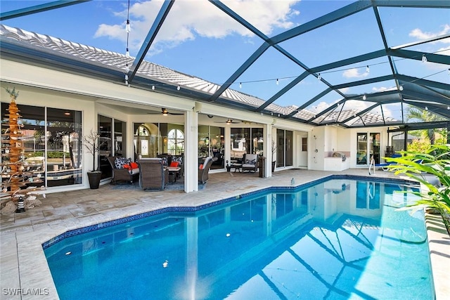 view of pool with a lanai, ceiling fan, and a patio