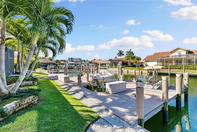 dock area with a water view and a lawn