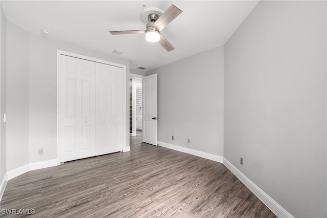 unfurnished bedroom featuring ceiling fan, a closet, and dark hardwood / wood-style flooring