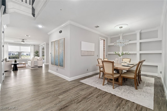 dining area featuring ceiling fan with notable chandelier, hardwood / wood-style floors, built in features, and ornamental molding