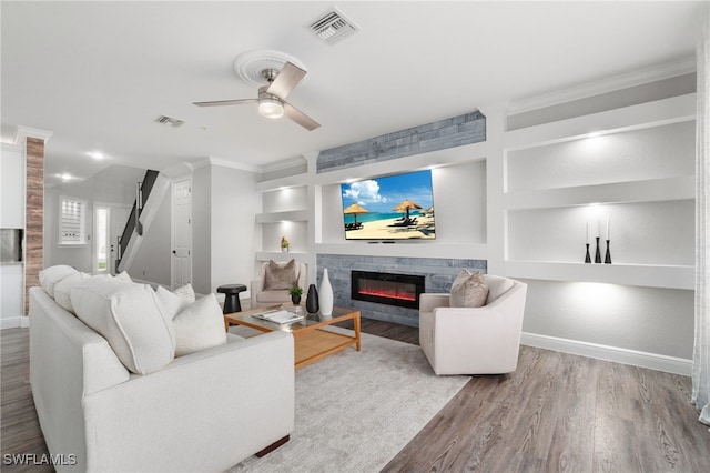 living room with ceiling fan, ornamental molding, built in features, and wood-type flooring