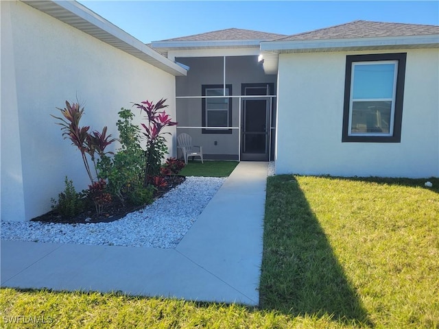 property entrance featuring a lawn