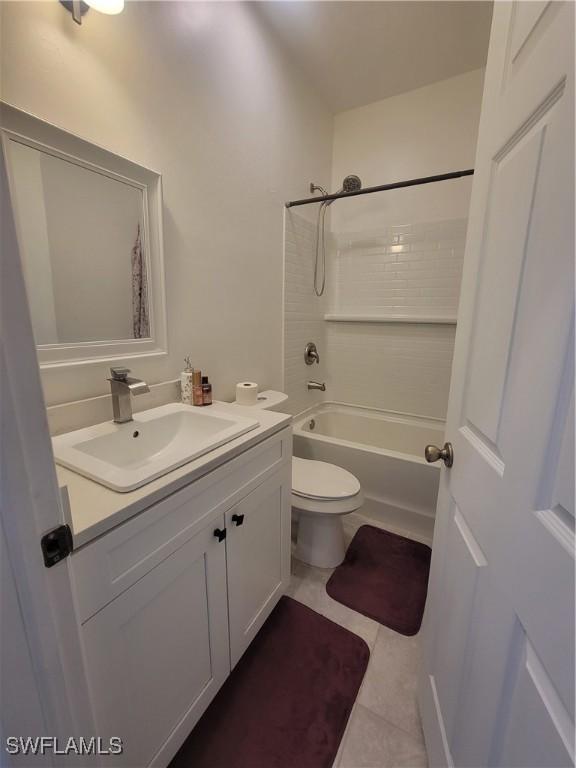 full bathroom with tile patterned floors, vanity, shower / bathtub combination, and toilet