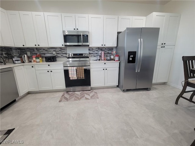 kitchen featuring decorative backsplash, white cabinetry, and appliances with stainless steel finishes