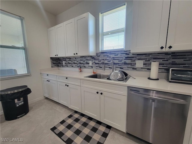 kitchen featuring white cabinets, stainless steel dishwasher, and sink