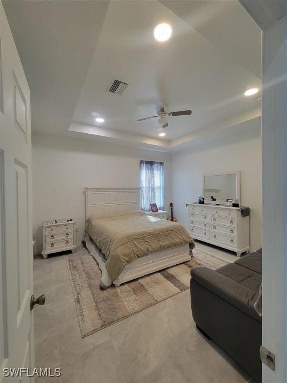 bedroom with ceiling fan and a raised ceiling