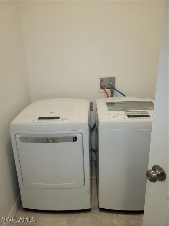 laundry room featuring light tile patterned floors and washing machine and dryer