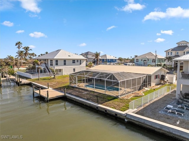 dock area with glass enclosure, a patio area, a water view, and a pool