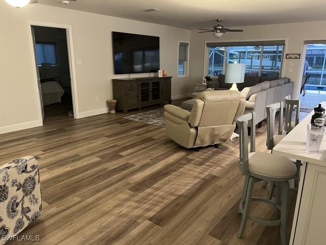 living room featuring dark hardwood / wood-style flooring and ceiling fan