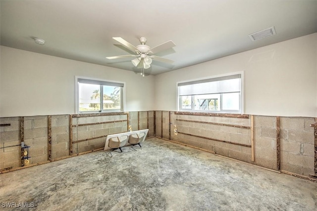 unfurnished room featuring ceiling fan and a healthy amount of sunlight