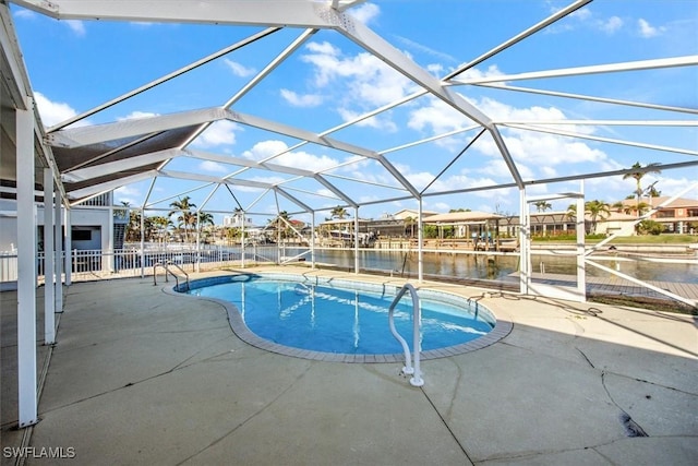 view of pool with a patio, a water view, and glass enclosure