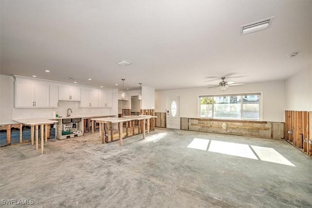 living room featuring ceiling fan and sink