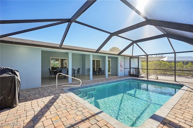 view of pool featuring glass enclosure and a patio area