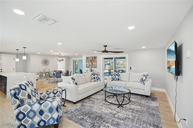 living room with light wood-type flooring and ceiling fan