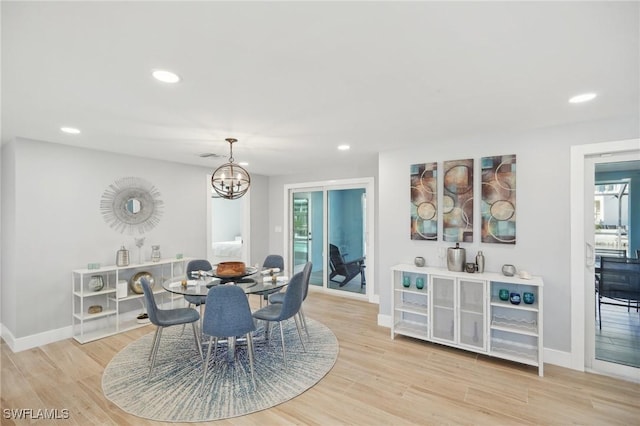 dining area with a notable chandelier, light hardwood / wood-style floors, and a healthy amount of sunlight