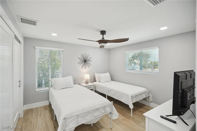 bedroom with multiple windows, ceiling fan, and a closet