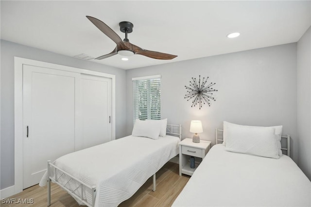 bedroom featuring ceiling fan, a closet, and light wood-type flooring