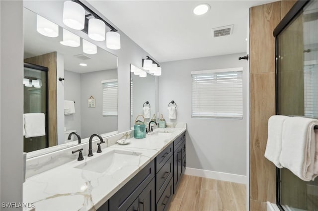 bathroom with hardwood / wood-style floors, vanity, and walk in shower