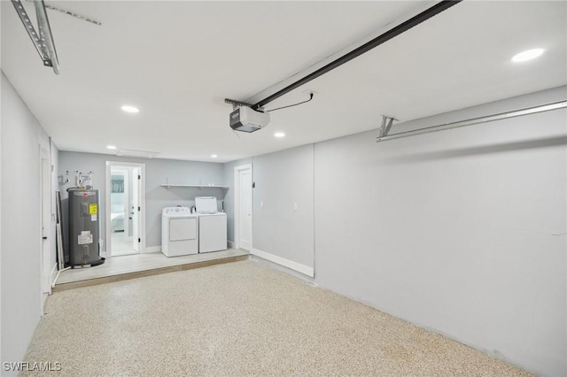 garage featuring water heater, washer and dryer, and a garage door opener