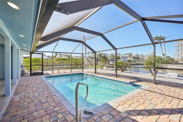 view of pool featuring a water view, glass enclosure, and a patio area