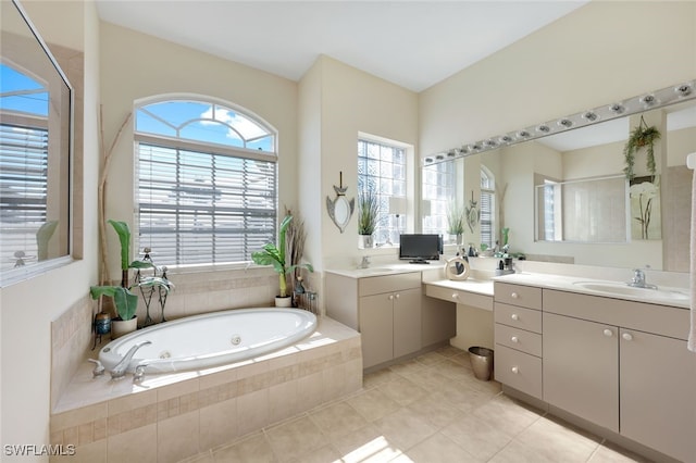 bathroom with vanity, tile patterned flooring, and tiled tub