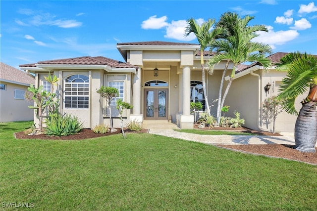 view of front of house with a garage, a front lawn, and french doors