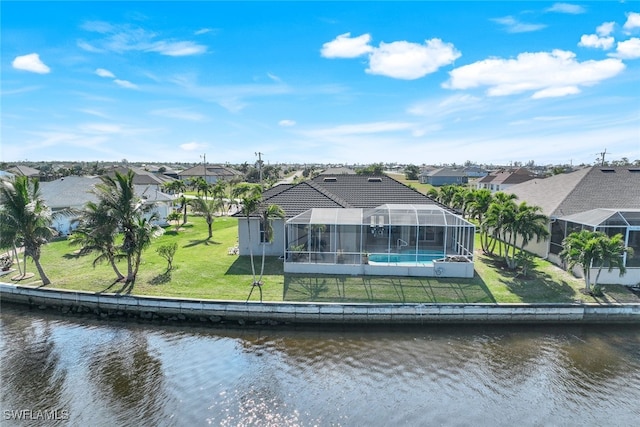 back of house featuring a water view, a lanai, and a yard