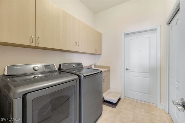 washroom with cabinets, sink, and washer and clothes dryer