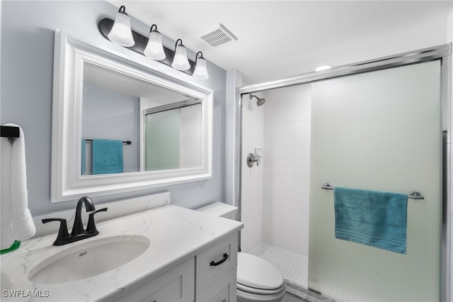 bathroom with an enclosed shower, vanity, and toilet