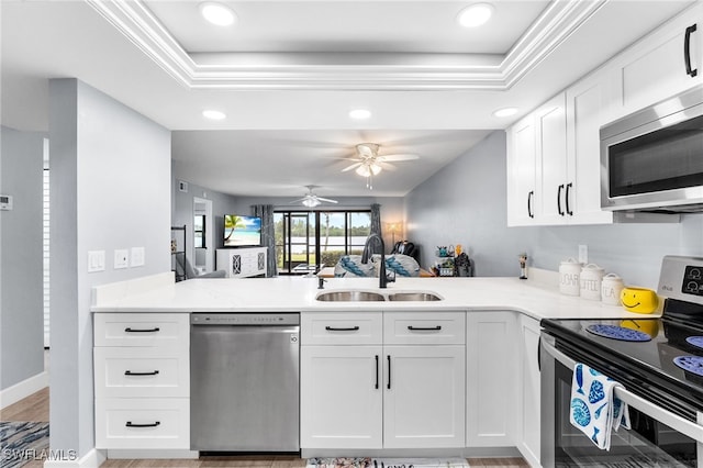 kitchen featuring white cabinetry, appliances with stainless steel finishes, kitchen peninsula, and sink