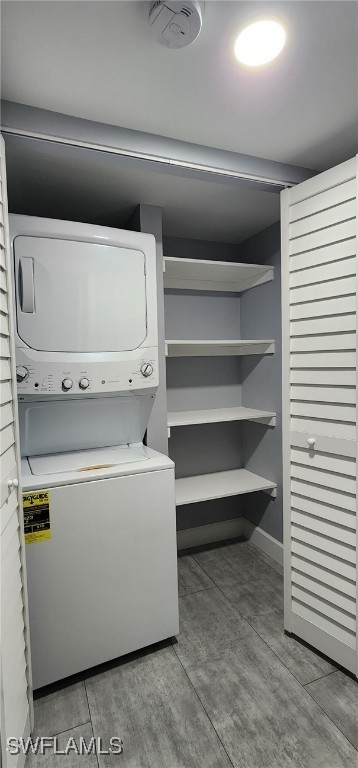 laundry area featuring light hardwood / wood-style flooring and stacked washing maching and dryer