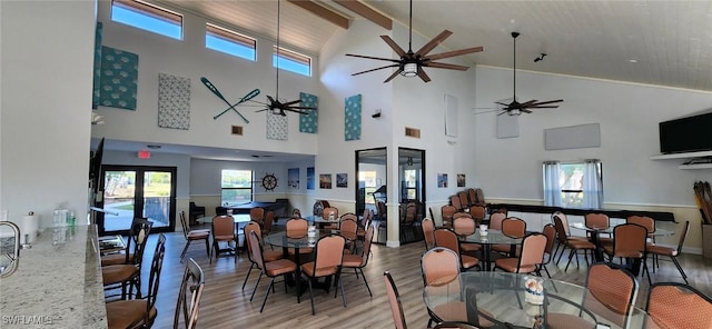 dining area with wood-type flooring, lofted ceiling with beams, and ceiling fan