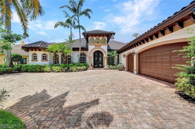 mediterranean / spanish house featuring french doors and a garage