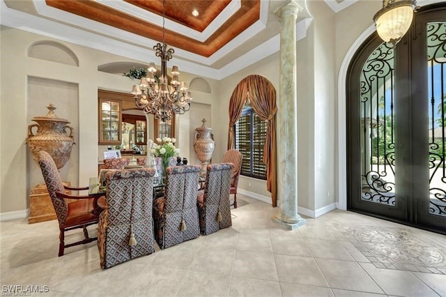 tiled dining space with a notable chandelier, a healthy amount of sunlight, ornamental molding, and french doors