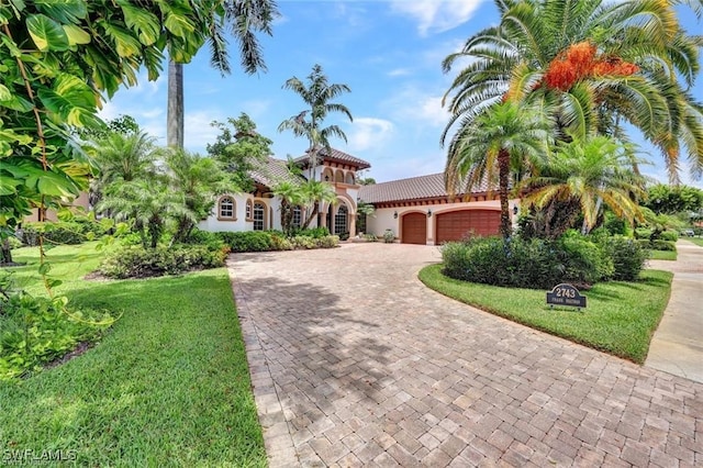 mediterranean / spanish house with a garage and a front yard