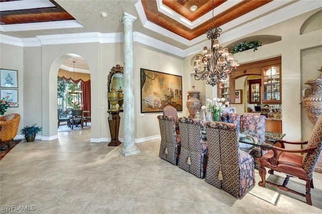 dining space featuring a raised ceiling, a chandelier, a high ceiling, and ornamental molding